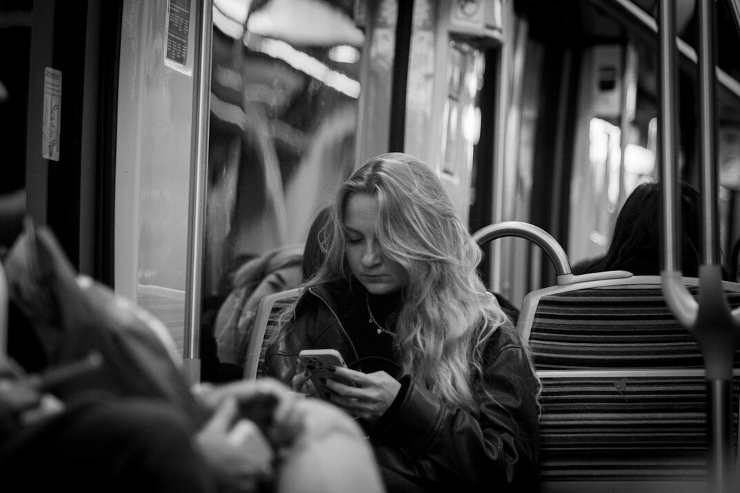 Young german woman scrolling on a smartphone while sitting on a train
